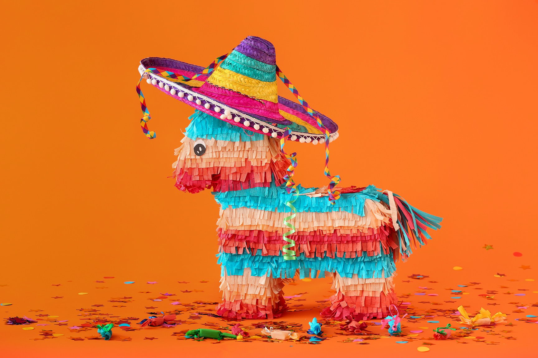 Mexican Pinata with Sombrero Hat and Confetti on Orange Background